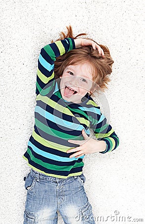 Young boy fooling around and playing on the floor Stock Photo
