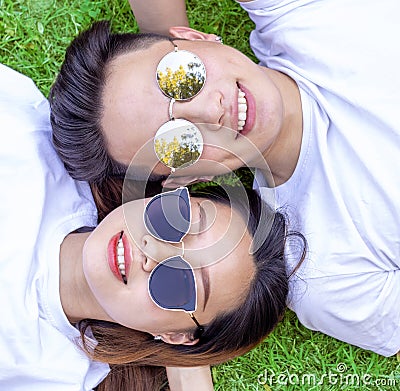 Young boy and girl with sunglasses lying down on grass and smilin Stock Photo