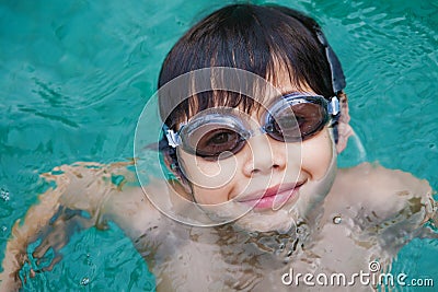 Young boy with goggles swimming in pool Stock Photo