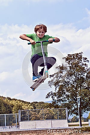 Young boy going airborne with his scooter Stock Photo