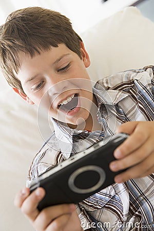 Young boy with handheld game indoors Stock Photo