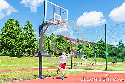 Young boy having fun playing basketball outdoors.nice,cool caucasian alone player playing basketball outdoors Stock Photo