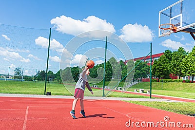 Young boy having fun playing basketball outdoors.nice,cool caucasian alone player playing basketball outdoors Stock Photo