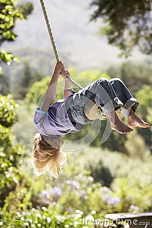 Young Boy Having Fun On Rope Swing Stock Photo