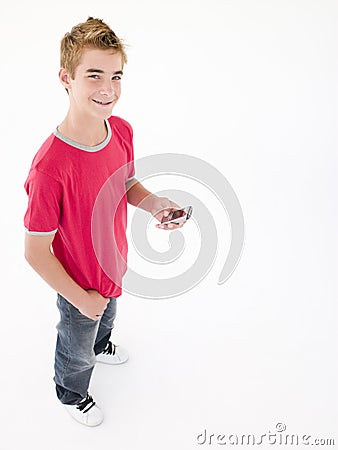 Young boy holding cellular phone and smiling Stock Photo