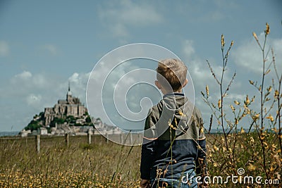 Young boy looking at Mont Saint-Michel in France Stock Photo