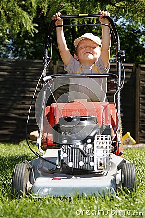 Young boy mowing grass Stock Photo