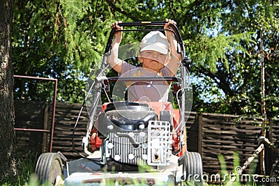 Young boy mowing grass Stock Photo