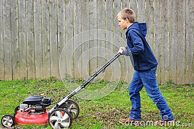 Young Boy Mowing Lawn Stock Photo