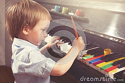 Young boy painting piano keys. Fine arts and music. True art. Stock Photo