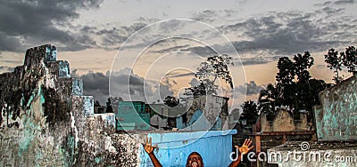 A young Haitian boy photobombs a missionary`s picture of a rural Haitian cemetery. Editorial Stock Photo