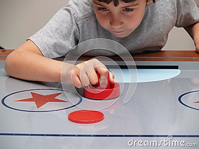 Young boy playing air hockey Stock Photo