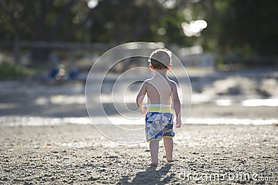 Young boy playing on the mudflats in the setting sun Stock Photo