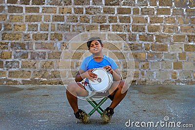 Chania, Crete / Greece - September 15 2019 Young boy playing music on street trying to ear money with music. Editorial Stock Photo