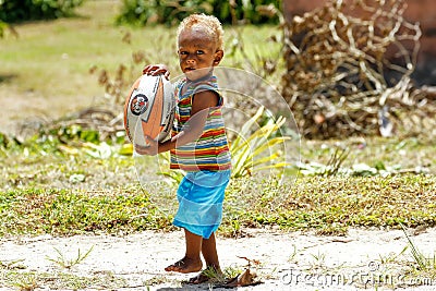 Young boy playing with rugby ball in Lavena village, Taveuni Isl Editorial Stock Photo