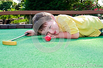 Young boy plays mini golf Stock Photo
