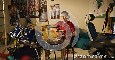 Young boy practices musician skills using drum kit Stock Photo