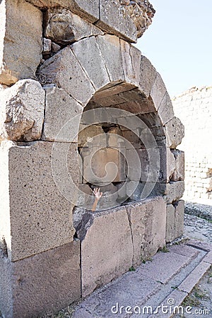 Young boy pretending to be a zombie in the ancient bath of Pergamon, Turkey - hand from the crypt Stock Photo