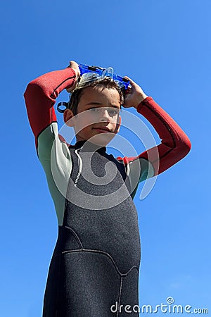 Young boy ready for diving in diving suit puts on diving mask Stock Photo