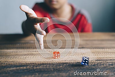 Young boy rolling / throwing a dice Stock Photo