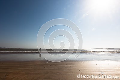 Young boy running on ocean beach wants to catch a ball from water Stock Photo