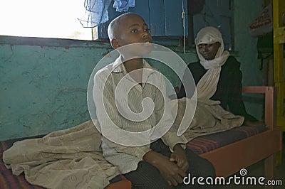 A young boy sits at the bedside of his mother who is infected with HIV/AIDS at Pepo La Tumaini Jangwani, HIV/AIDS Community Editorial Stock Photo