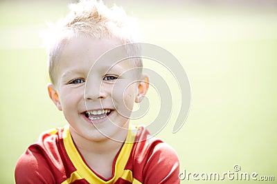 Young boy sitting on football field Stock Photo