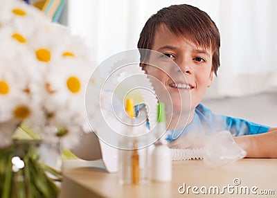 Young boy smiling from behind a nebulizer inhaler device Stock Photo