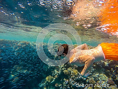 Young boy Snorkel swim in shallow water with coral school of fish Stock Photo