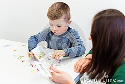Young boy in speech therapy office. Preschooler exercising correct pronunciation with speech therapist. Child Occupational Therapy Stock Photo