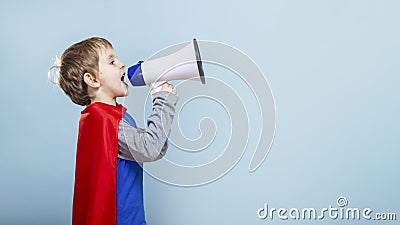 Young boy in superhero costume shouting into megaphone. Stock Photo