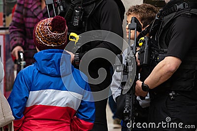 Young boy talking and looking at armed police during tour de yorkshire Editorial Stock Photo