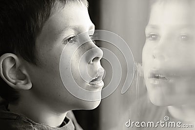 Young boy in thought with window reflection Stock Photo