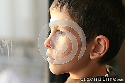 Young boy in thought with window reflection Stock Photo