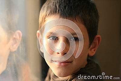 Young boy in thought with window reflection Stock Photo