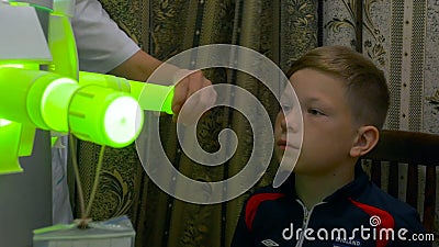 Young boy undergoing treatment in modern clinic. laser inhalation. light inhalation treatment of throat UV Editorial Stock Photo