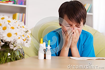 Young boy with various nose sprays sneezing in allergy season Stock Photo