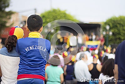 Young boy with Venezuelan watching a stage at Venezuelan protest Editorial Stock Photo