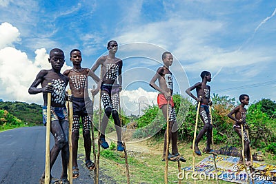 Young Boys of Benna Tribe with Traditional Body Painting on the Long Wooden Sticks posing for the picture Editorial Stock Photo