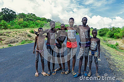 Young Boys of Benna Tribe with Traditional Body Painting on the Long Wooden Sticks posing for the picture Editorial Stock Photo