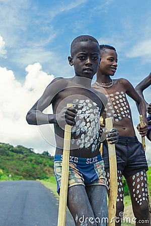 Young Boys of Benna Tribe with Traditional Body Painting on the Long Wooden Sticks posing for the picture Editorial Stock Photo