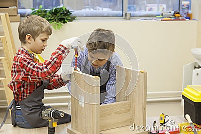 Young boys construct wooden stool Stock Photo