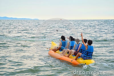 Young boys and girl riding on the banana boat on the sea in Pattaya, Thailand. Editorial Stock Photo