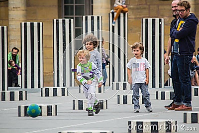 Young boys play soccer amidst the Colonnes de Buren, Palais Royal, Paris Editorial Stock Photo