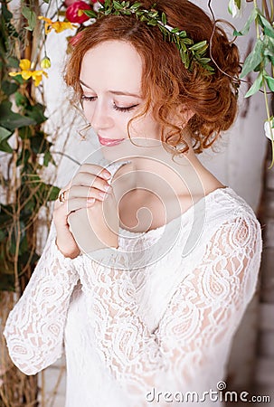Young bride in a green wreath praying for happyness Stock Photo