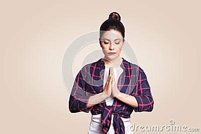 Young brunete woman practising yoga, holding hands in namaste and keeping her eyes closed. Caucasian girl meditating Stock Photo