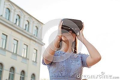 Young brunette is amused by her first encounter with futurist virtual reality glasses Stock Photo