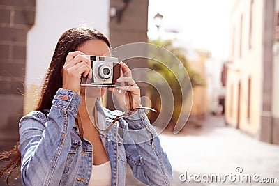 Young brunette focusing her old camera Stock Photo