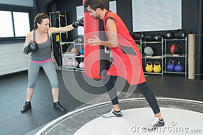 Young brunette getting boxing lessons from man Stock Photo