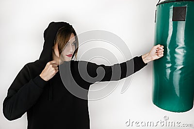 Young brunette strong woman exercising hitting boxing bag on isolated on white background Stock Photo